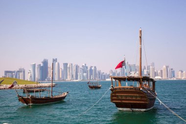 Doha, Katar - 24 Nisan 2022: Arka planda Doha 'nın fütüristik silueti olan geleneksel dhow gemileri.