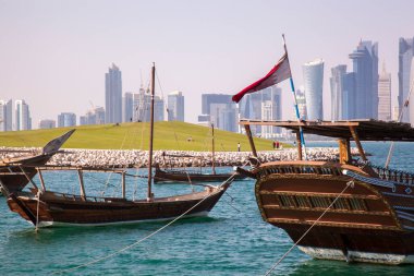 Doha, Katar - 24 Nisan 2022: Arka planda Doha 'nın fütüristik silueti olan geleneksel dhow gemileri.