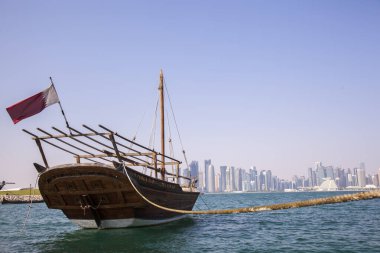 Doha, Katar - 24 Nisan 2022: Arka planda Doha 'nın fütüristik silueti olan geleneksel dhow gemileri.