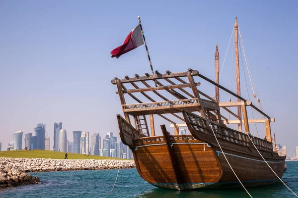 Doha, Katar - 24 Nisan 2022: Arka planda Doha 'nın fütüristik silueti olan geleneksel dhow gemileri.