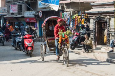 Kathmandu, Nepal - 20 Nisan 2019: Katmandu sokaklarında bisiklet arabası. Nepal 'in terai bölgesinde, bisiklet çekçekçekçekleri hala kısa mesafe ulaşımı için en popüler toplu taşıma araçlarıdır..