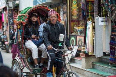 Kathmandu, Nepal - 20 Nisan 2019: Katmandu sokaklarında bisiklet arabası. Nepal 'in terai bölgesinde, bisiklet çekçekçekçekleri hala kısa mesafe ulaşımı için en popüler toplu taşıma araçlarıdır..