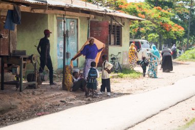 Zanzibar City, Tanzania - May 01,2022: Street view of the usual daily life of local people all ages taking place along the road on the Zanzibar Island in Tanzania.