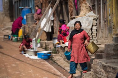 Katmandu, Nepal - 20 Nisan 2022: Kadınlar Patan Durbar Meydanı sokaklarında çamaşır ve bulaşıkları yıkıyorlar.