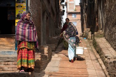 Katmandu, Nepal - 20 Nisan 2022: Kadınlar Patan Durbar Meydanı sokaklarında çamaşır ve bulaşıkları yıkıyorlar.