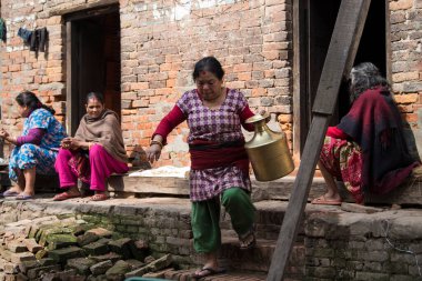 Katmandu, Nepal - 20 Nisan 2022: Kadınlar Patan Durbar Meydanı sokaklarında çamaşır ve bulaşıkları yıkıyorlar.