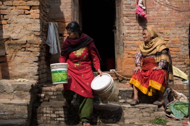 Katmandu, Nepal - 20 Nisan 2022: Kadınlar Patan Durbar Meydanı sokaklarında çamaşır ve bulaşıkları yıkıyorlar.