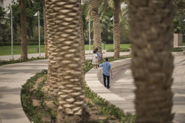 Doha, Katar - 05 Mart 2019: Doha 'daki İslam Sanatları Müzesi' nin parkında güneşli bir günün tadını çıkaran insanlar.