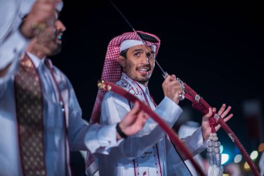 Doha, Katar, Aralık-18.2017: Darb Al Saai sahasında yapılan kılıç dansı, Katar Ulusal Günü 'nü kılıçlarla dans geleneğini sürdüren yerel halkla kutlamak için düzenlendi..