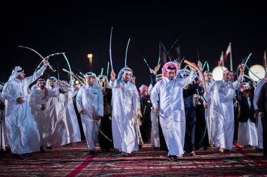 Doha, Katar, Aralık-18.2017: Darb Al Saai sahasında yapılan kılıç dansı, Katar Ulusal Günü 'nü kılıçlarla dans geleneğini sürdüren yerel halkla kutlamak için düzenlendi..
