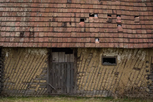 Croatia, October 20,2022 : Facade of mud and straw on old wooden house.