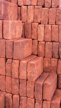 Düzenli olarak düzenlenmiş kırmızı tuğla yığınının portre görüntüsü, merdiveni oluşturan tuğla yığınları, inşaat malzemeleri, tuğla yapı, tuğla duvar dokusu, dizayn için kırmızı desen arka planı