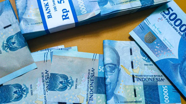 Pasangkayu naipliği, Endonezya - 17 Mart 2022: Endonezya rupisinin kağıt parası. Finans, iş ve başarı kavramı. Paranı biriktiriyorum. Uang 50000 Rupiah Endonezya. İzole turuncu arkaplan