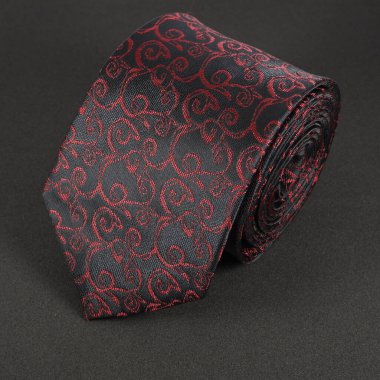 Çiçek desenli klasik kravat siyah arkaplan arkaplanına yakın görüntüde yuvarlandı tek bir nesne 