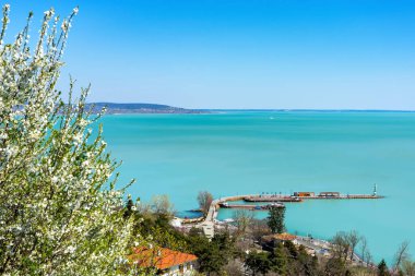 Balaton Gölü 'ndeki Tihany Manastırı' ndan Tihany Rıhtımı 'nın çiçek açan ağaçlarıyla dolu bahar manzarası