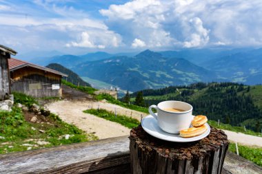 Tyrol 'da dağların tepesinde kahvaltıda bir fincan kahve içmek.