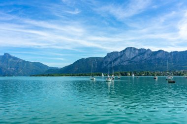 Mondsee 'de dağlar ve yelkenli tekneler yaz mevsiminde .