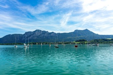 Mondsee 'de dağlar ve yelkenli tekneler yaz mevsiminde .