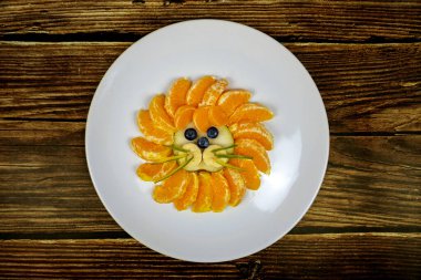 Komik aslan surat kompozisyonu, ahşap masadaki turuncu yaban mersini gibi meyvelerle. .