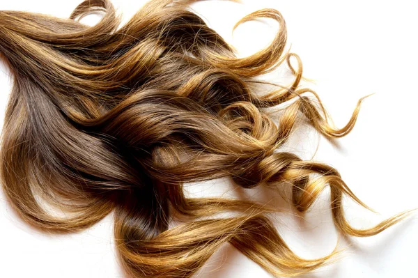 Beyaz izole edilmiş arka planda kahverengi kıvırcık saçlar.