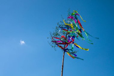 May tree, traditional hungarian austrian german folklore colorful decoration with ribbons in may with blue sky clipart