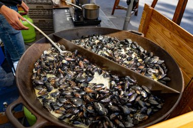 Ljubljana dprta kuhna 'da büyük bir tavada siyah midye açık mutfak etkinliği .