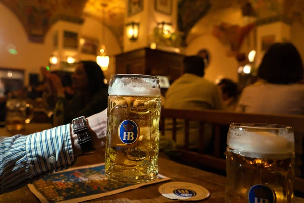 Münih, Almanya - 04.07.2022: Münih 'te HB biralı sürahi Krugel tutan ünlü hofbrauhaus geleneksel pud keller