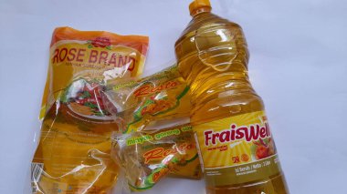 Bekasi, Endonezya - Mart 2022: Beyaz arka planda palmiye yağı şişeleri ve plastik keseler. arka plan aşçılığı konsepti, temel ihtiyaçlar, yaşam tarzı, minimarket, süpermarket, market, şehir