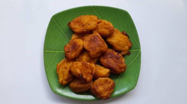 Yukarıdan beyaz arka planda görünen bir tabakta kızarmış bant. Cassava işlenmiş arka plan kavramı, kolesterol yiyeceği, geleneksel atıştırmalıklar, aşçılık, yemek tarifleri, işletme, finans, restoran, yaşam tarzı