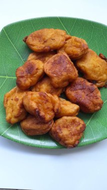 Yukarıdan görünen bir tabakta kızarmış bant. Cassava işlenmiş gıda geçmişi, kolesterol yiyeceği, geleneksel atıştırmalıklar, aşçılık, yemek tarifleri, yaşam tarzı, kahvaltı, pasta, pasta, öğle yemeği, diyet, akşam yemeği.