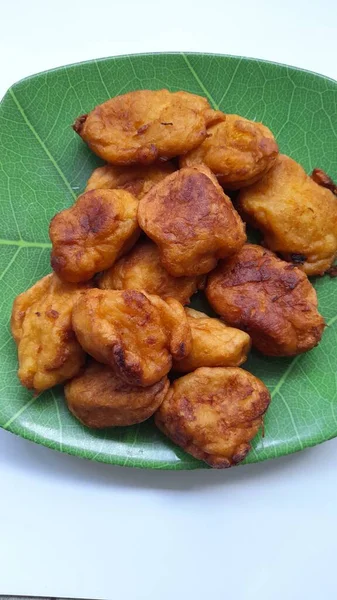 Yukarıdan görünen bir tabakta kızarmış bant. Cassava işlenmiş gıda geçmişi, kolesterol yiyeceği, geleneksel atıştırmalıklar, aşçılık, yemek tarifleri, yaşam tarzı, kahvaltı, pasta, pasta, öğle yemeği, diyet, akşam yemeği.