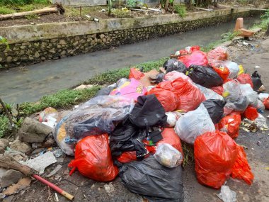 Bekasi, Endonezya - Haziran 2022: nehir kıyısında plastik atık. Endüstriyel arka plan konsepti, sanayi, hijyen, eğitim, kamuoyu bilinci, kirli, çöp, çöp, çöp, çevre, atık imhası