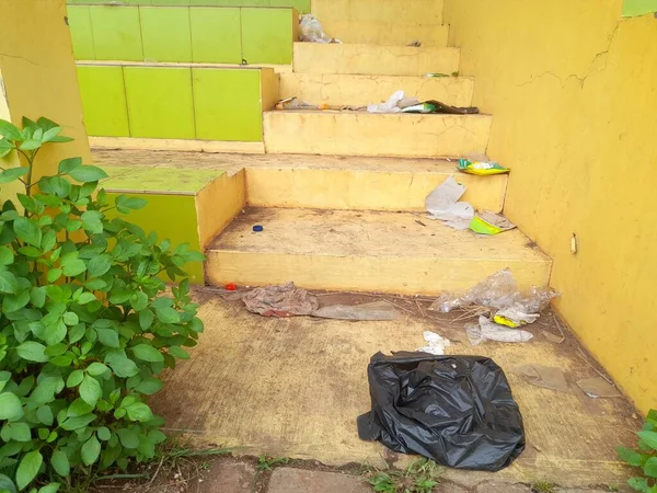 plastic waste, paper, cardboard scattered on the steps of the yard. the concept of background garbage, trash, industry, industrial, education, public awareness, dirty, clean, hygienic