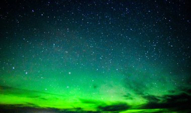 Northern lights in the night sky with stars and blue and green hues 