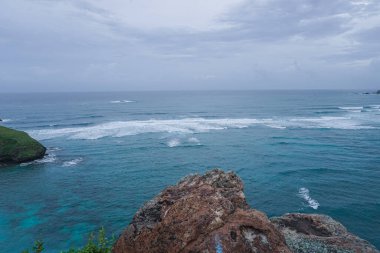 Dalgalar ve mavi suyla temiz sahil manzarası