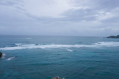 Dalgalar ve mavi suyla temiz sahil manzarası
