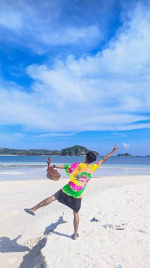 Tanjung, mavi gökyüzü güneşli bir sahil.