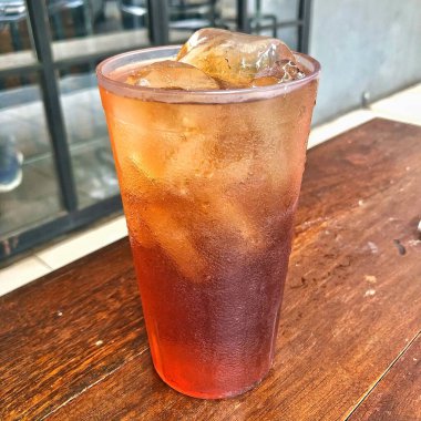 Tahta masada bir bardak buzlu çay. 