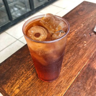 Tahta masada bir bardak buzlu çay. 