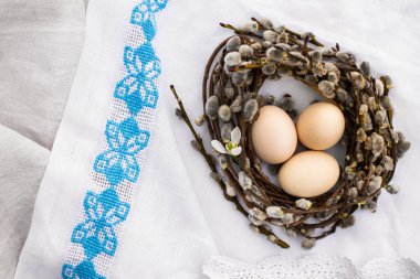 Beyaz keten işlemeli arka planda çiçek kovanındaki Paskalya yumurtaları düzleşmişti. Mutlu Paskalya tebrik kartları, mesaj ve üst görünüm için yer var. Ulusal Ukrayna çapraz dikiş nakışı