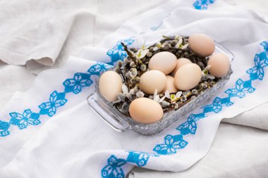 Beyaz keten işlemeli arka planda çiçek kovanındaki Paskalya yumurtaları düzleşmişti. Mutlu Paskalya tebrik kartları, mesaj ve üst görünüm için yer var. Ulusal Ukrayna çapraz dikiş nakışı