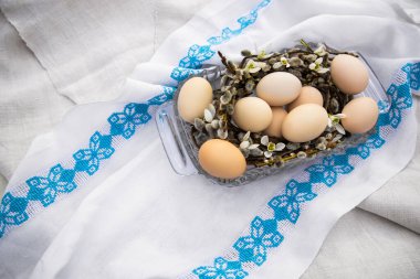 Beyaz keten işlemeli arka planda çiçek kovanındaki Paskalya yumurtaları düzleşmişti. Mutlu Paskalya tebrik kartları, mesaj ve üst görünüm için yer var. Ulusal Ukrayna çapraz dikiş nakışı