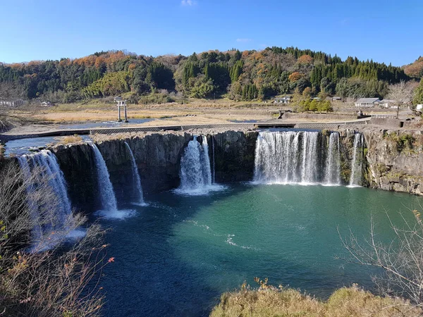 Beautiful arch shape waterfalls and countryside. Water flow through the Ogata River flows to form the waterfalls. A torii gate in the middle of the river. Bungoono, Oita, Kyushu, Japan