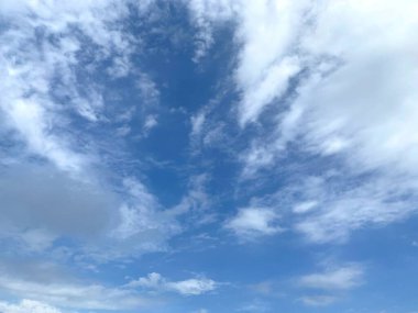 Gün ışığı, açık mavi gökyüzü ve yukarıda beyaz bulut.