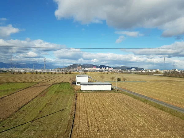 街を抜ける光の新幹線からの眺め 青い空 農場フィールド 住宅や伝送塔の風景ビュー 滋賀県 — ストック写真