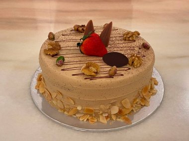 Badem gevreği, şam fıstığı ve cevizli kremalı kahve aromalı kek. Taze çilek ve çikolata ortaya..