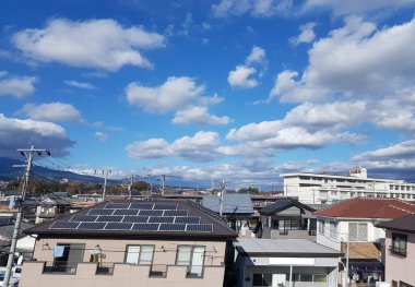 Kasabadan geçen bir Hikari Shinkansen 'in görüntüsü. Mavi gökyüzü ve dağ manzarası. Shiga Bölgesi, Japonya..