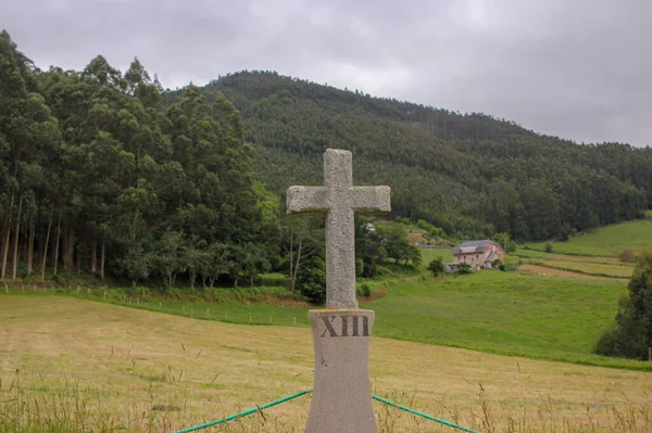 christian cross by the road in the way to a church