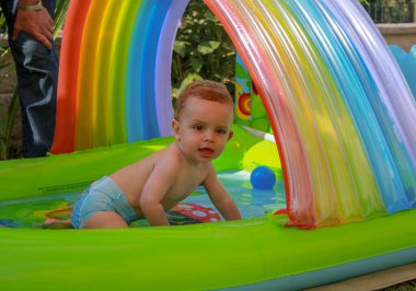 one year old child having a good time in the pool