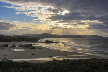 sunset in a north Spain beach with a lot of rocks in it